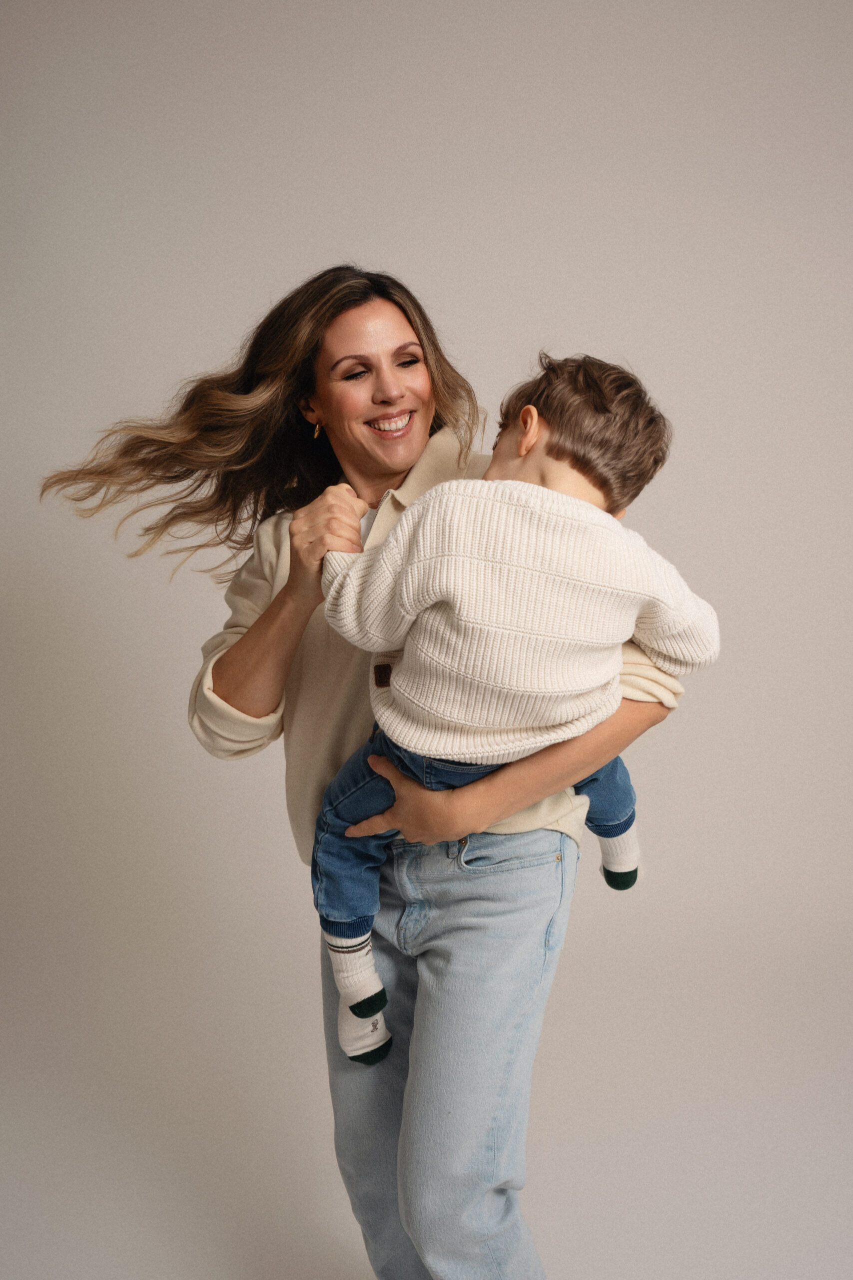 Mutter hält ihr Kind im Arm bei einem natürlichen Familien Fotoshooting im Studio