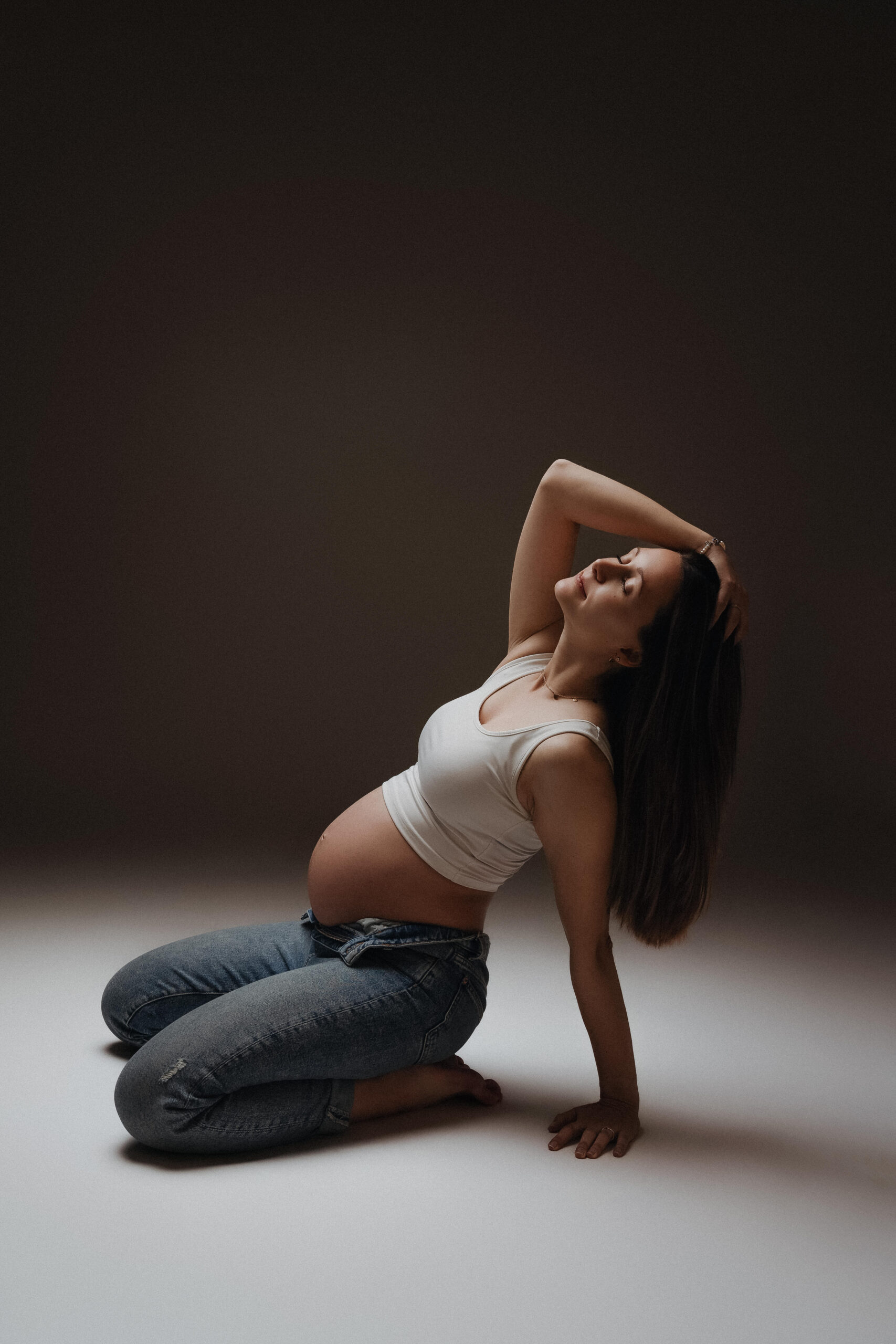 Schwangere Frau in natürlicher Pose bei einem emotionalen Babybauchshooting in Ulm.