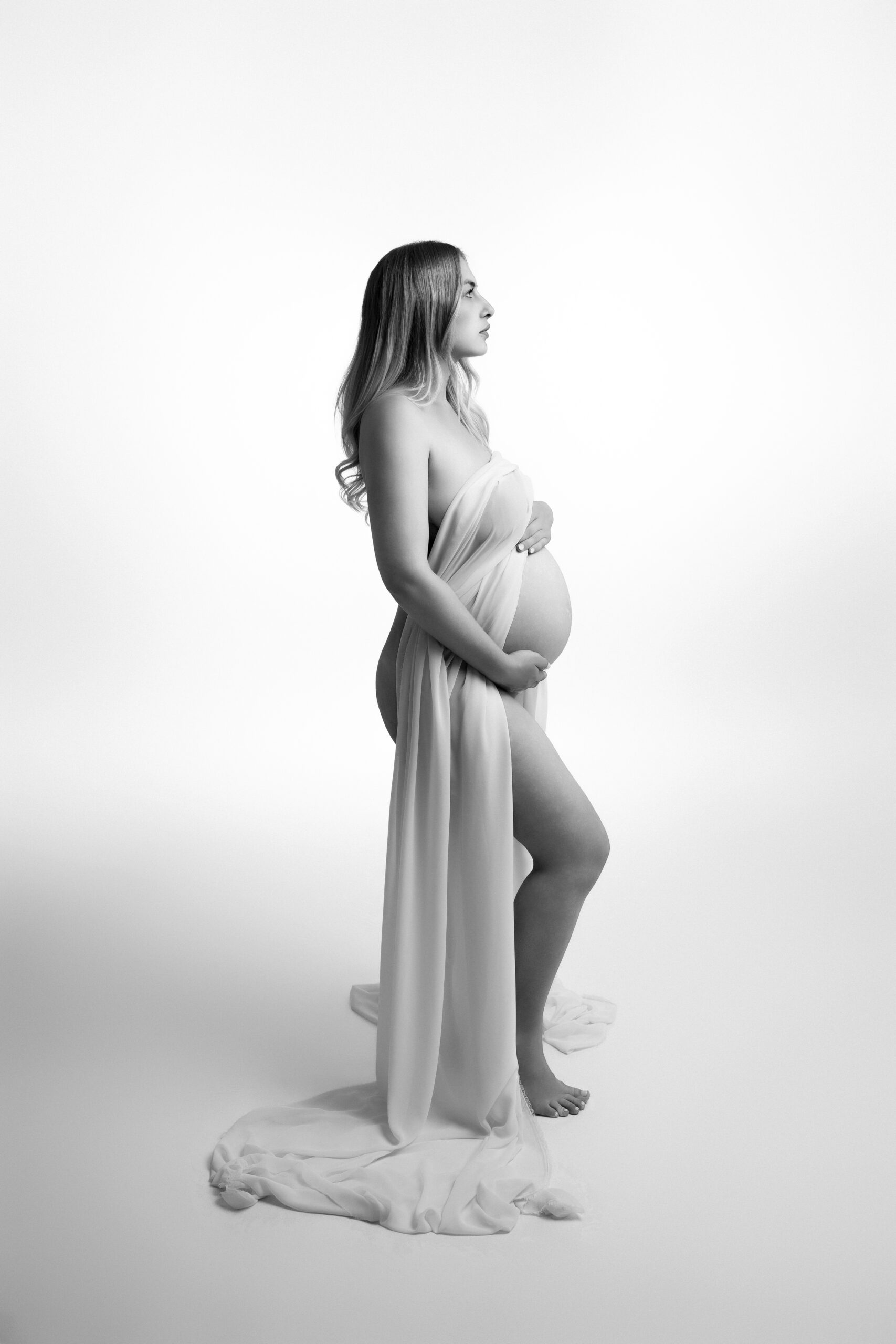Künstlerisches Fine-Art-Babybauchshooting in Ulm mit fließendem Stoff und zeitlosem Schwarzweiß-Look.