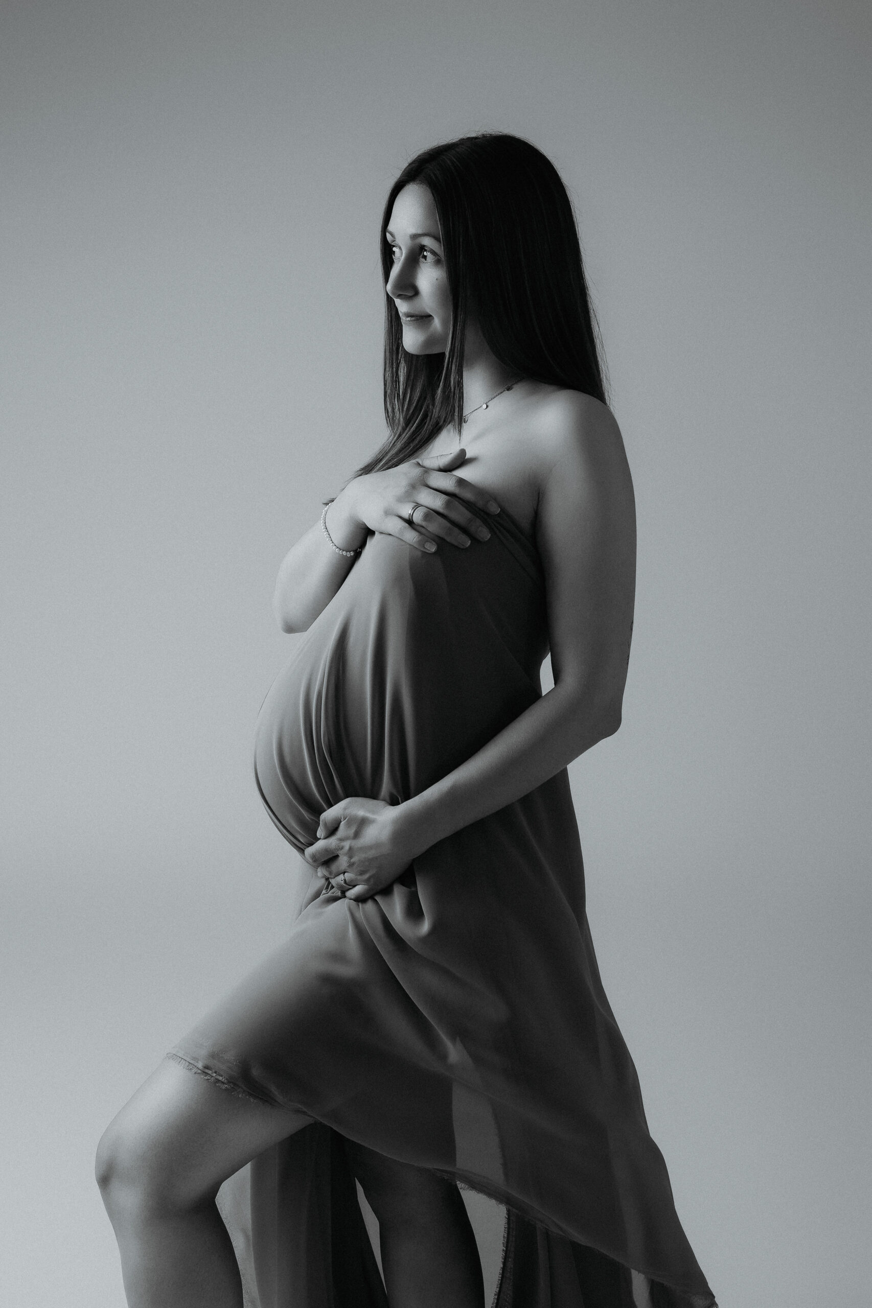 Fine-Art-Seitenprofil einer schwangeren Frau bei einem eleganten Babybauchshooting in Ulm.