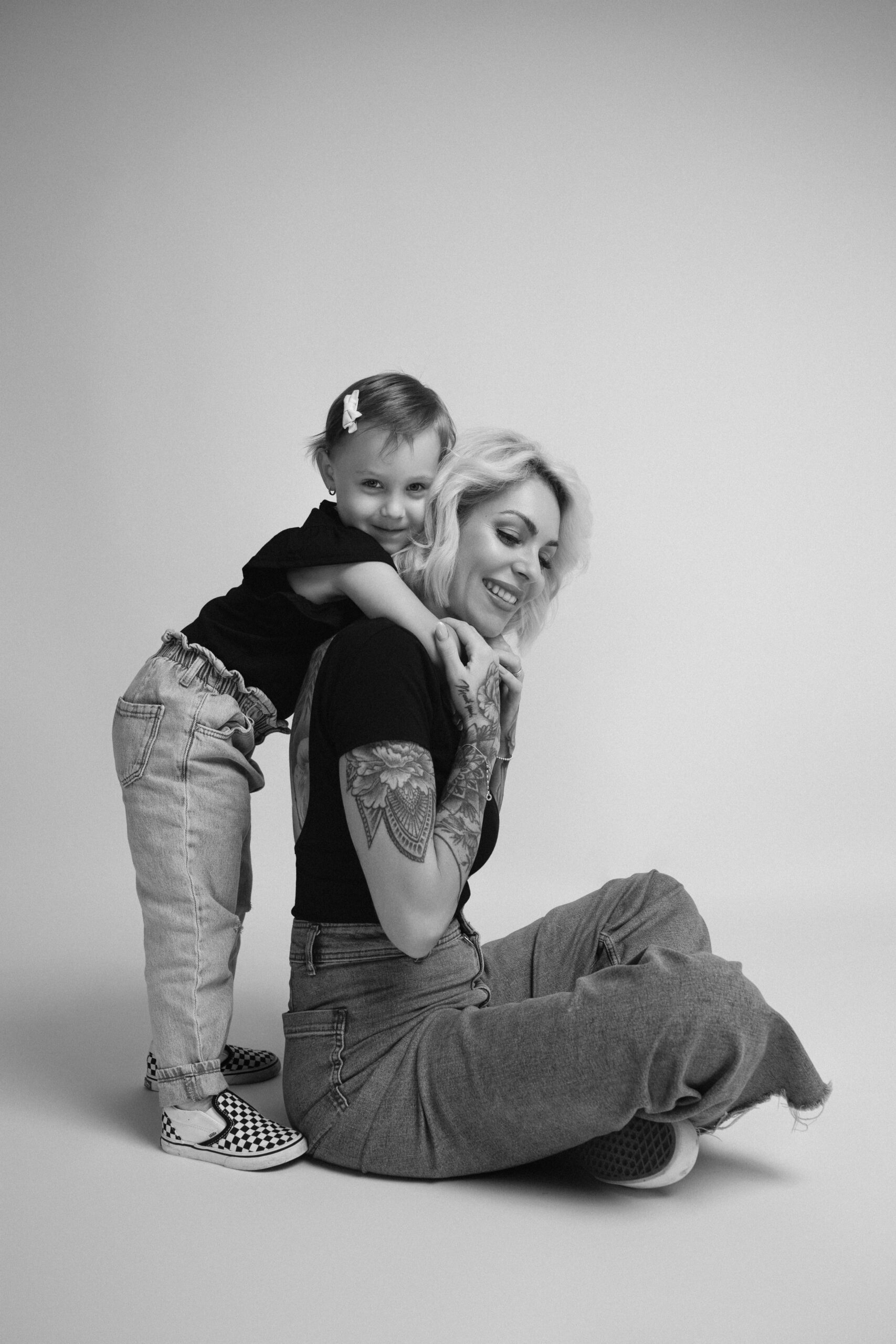 Verspieltes Schwarz-Weiß-Portrait von Mutter und Tochter mit inniger Umarmung bei einem Familienfotoshooting.