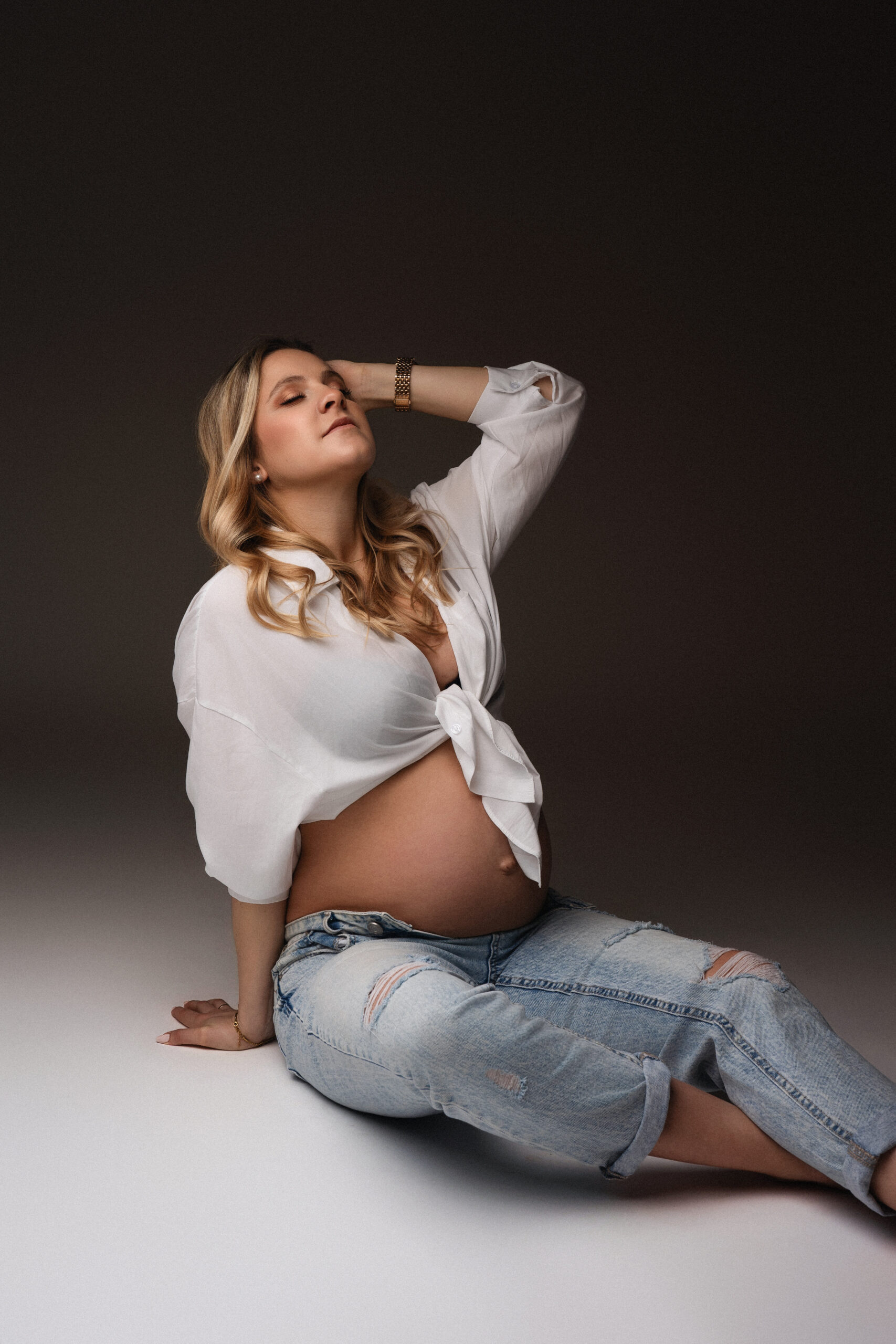 Schwangere Frau im lässigen Jeans-Look bei einem natürlichen Schwangerschaftsshooting in Ulm.