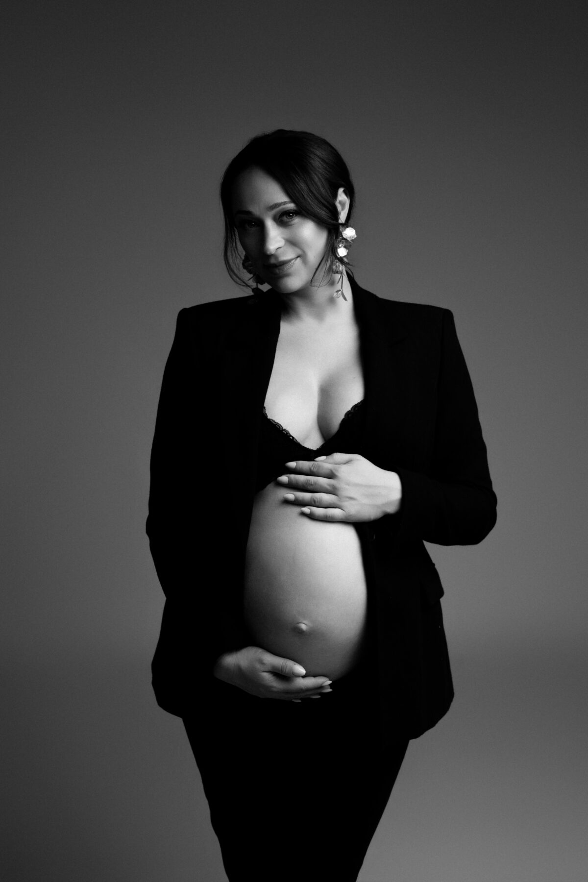 Schwangere Frau beim Babybauchshooting im Studio bei Ulm in Schwarz-Weiß mit schwarzem Blazer